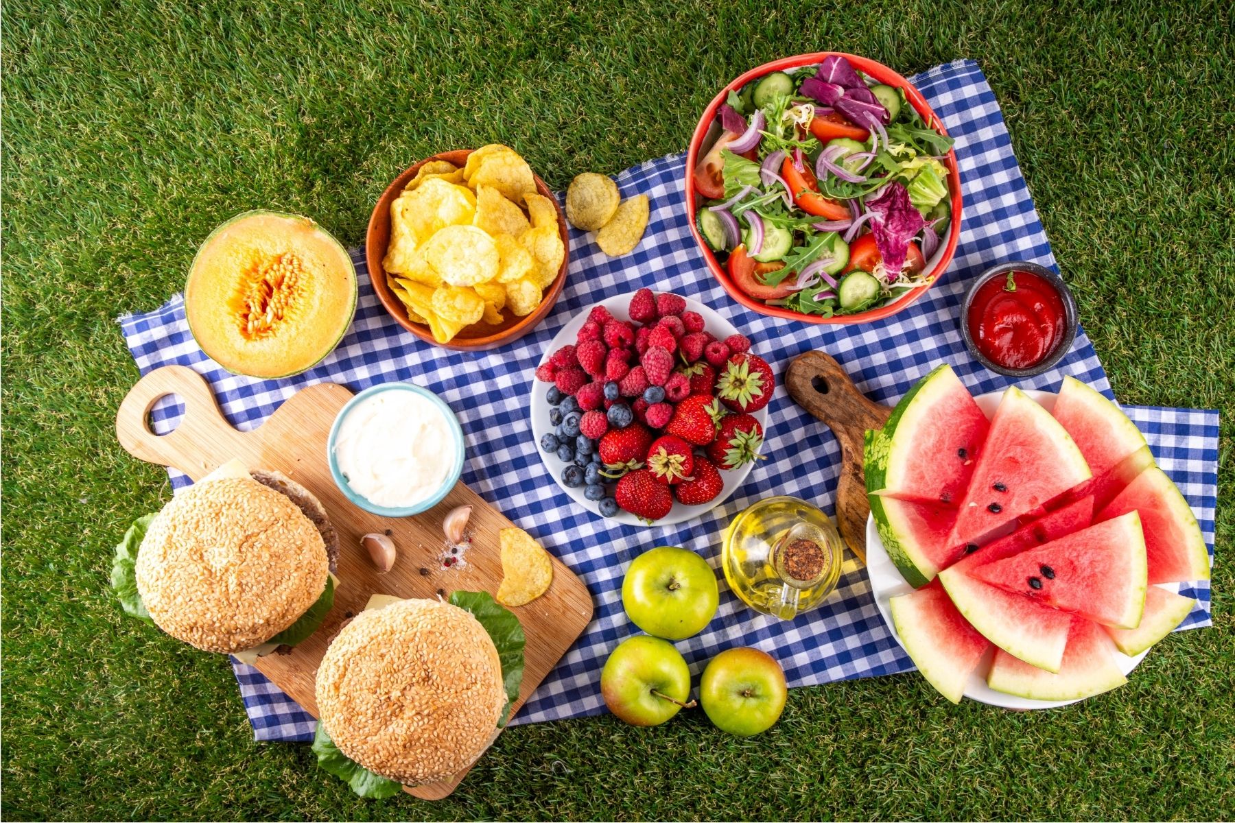 Healthy summer snacks including fruits, vegetables, yogurt, and cheese arranged for a family picnic.